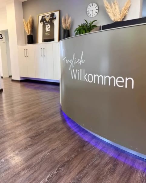 Empfangstresen mit der Aufschrift „Herzlich Willkommen“